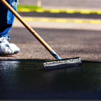 close up worker seal coating the drive way 1